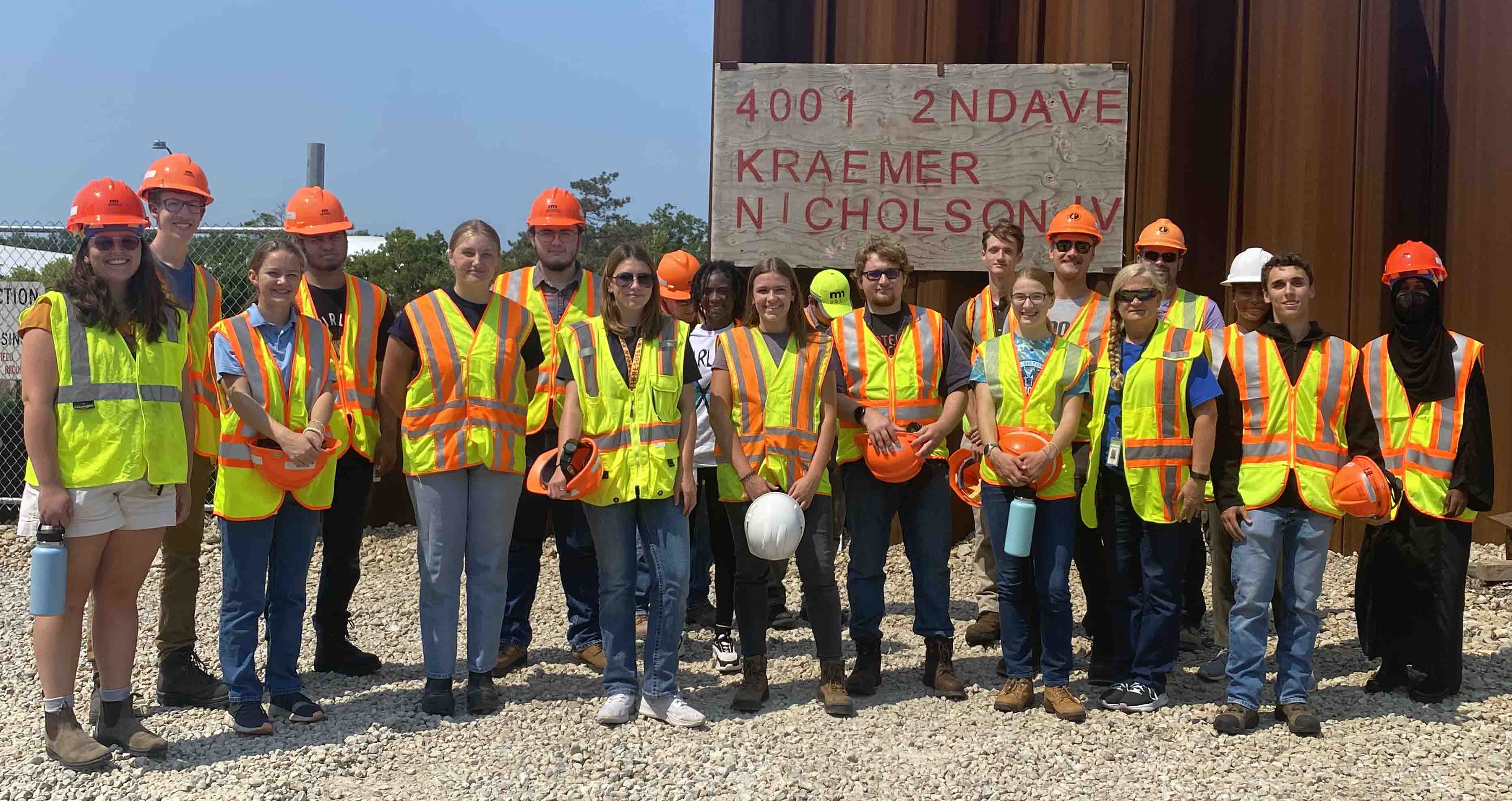 Students from the Civil Engineering and Phoenix Programs standing outside next to the address for the stomwater storage facility in south Minneapolis