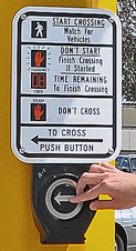 Pressing walk button at a crosswalk